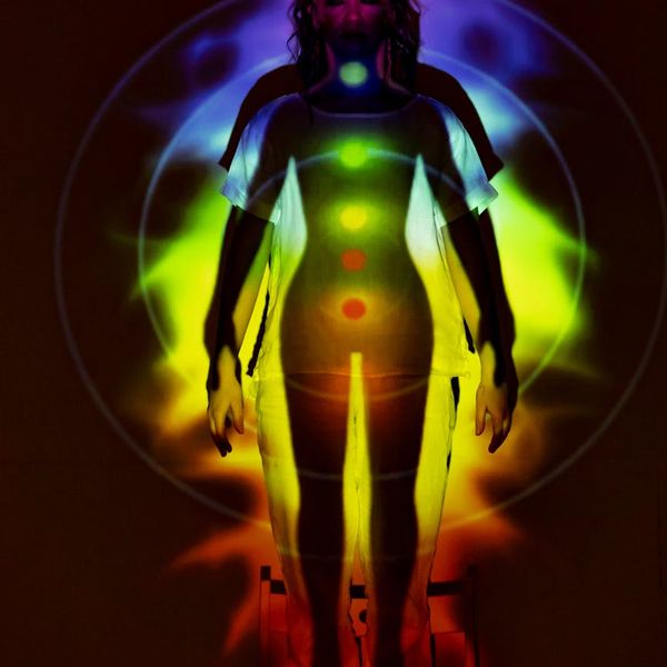 Silhouette of a person in a powerful yoga warrior pose against a rising sun.